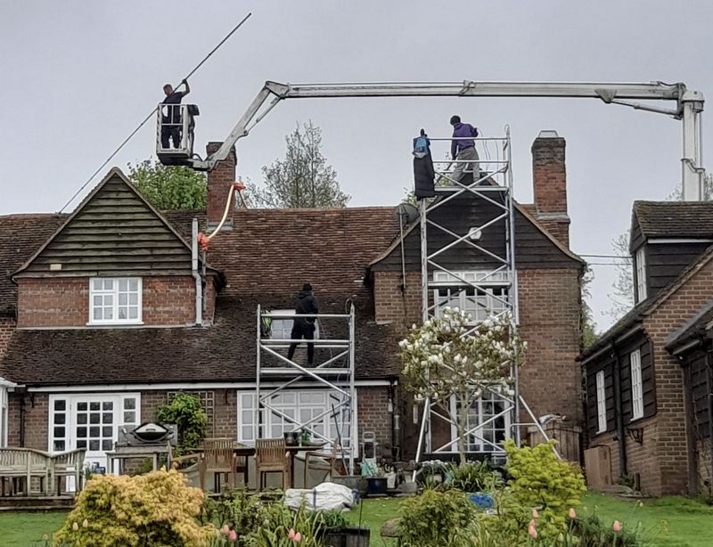 The Moss Cleaners using cherry picker and scaffolding to clean roof safely and professionally in Midhurst, West Sussex